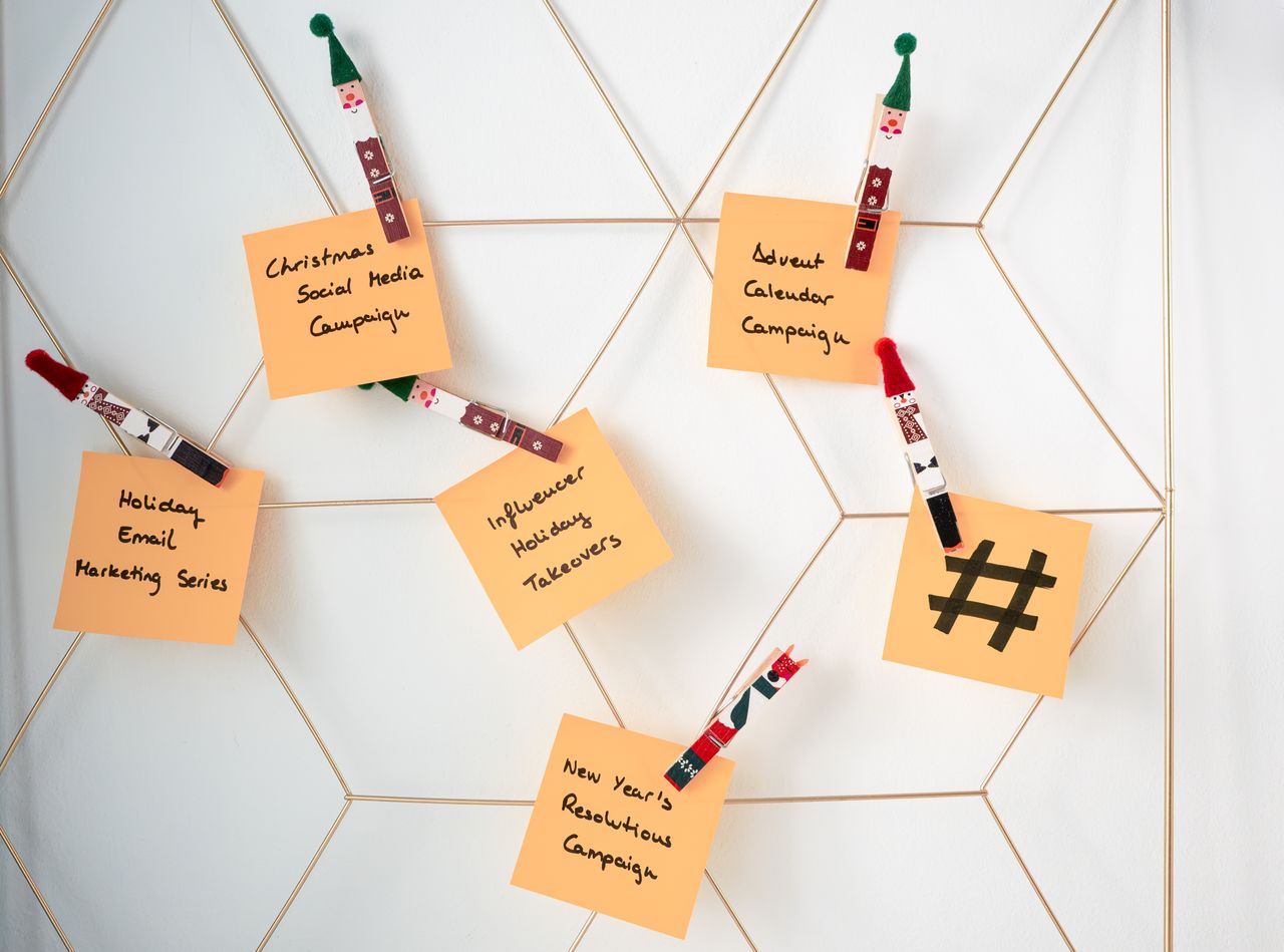 Notes adhésives avec des idées de marketing pour les fêtes, fixées sur une grille murale.